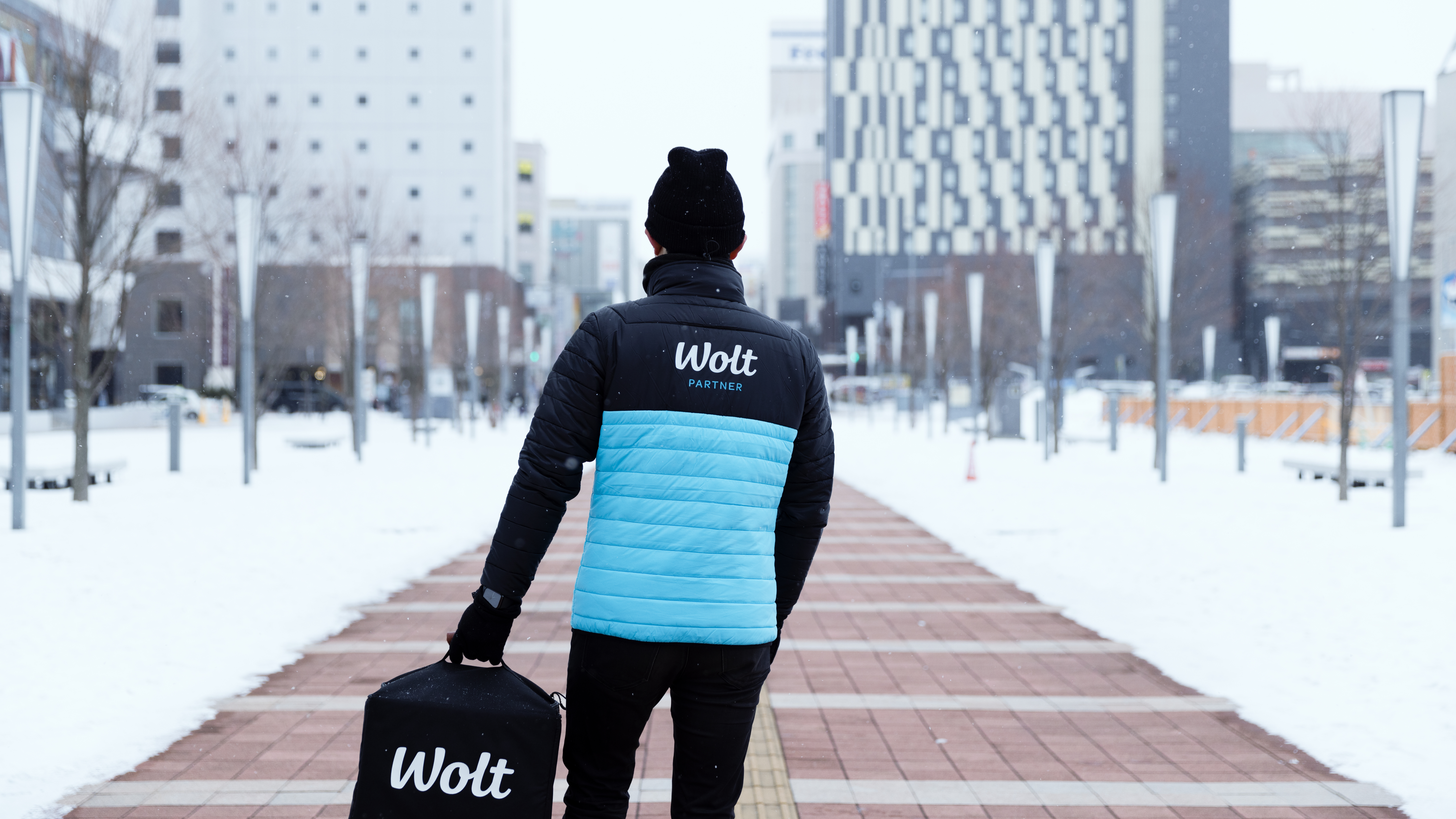 Wolt courier partner walking holding the Wolt heat bag